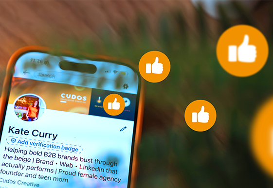 LinkedIn profile on a smartphone screen with engagement icons, illustrating how showing personality and authenticity on LinkedIn can increase visibility, engagement and business opportunities for B2B professionals.